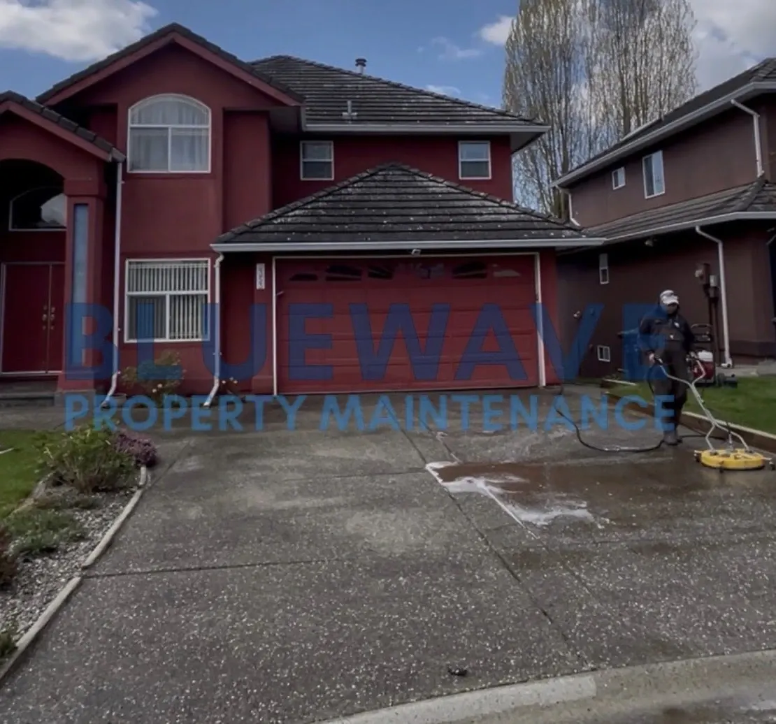 BlueWave technician pressure washing a driveway