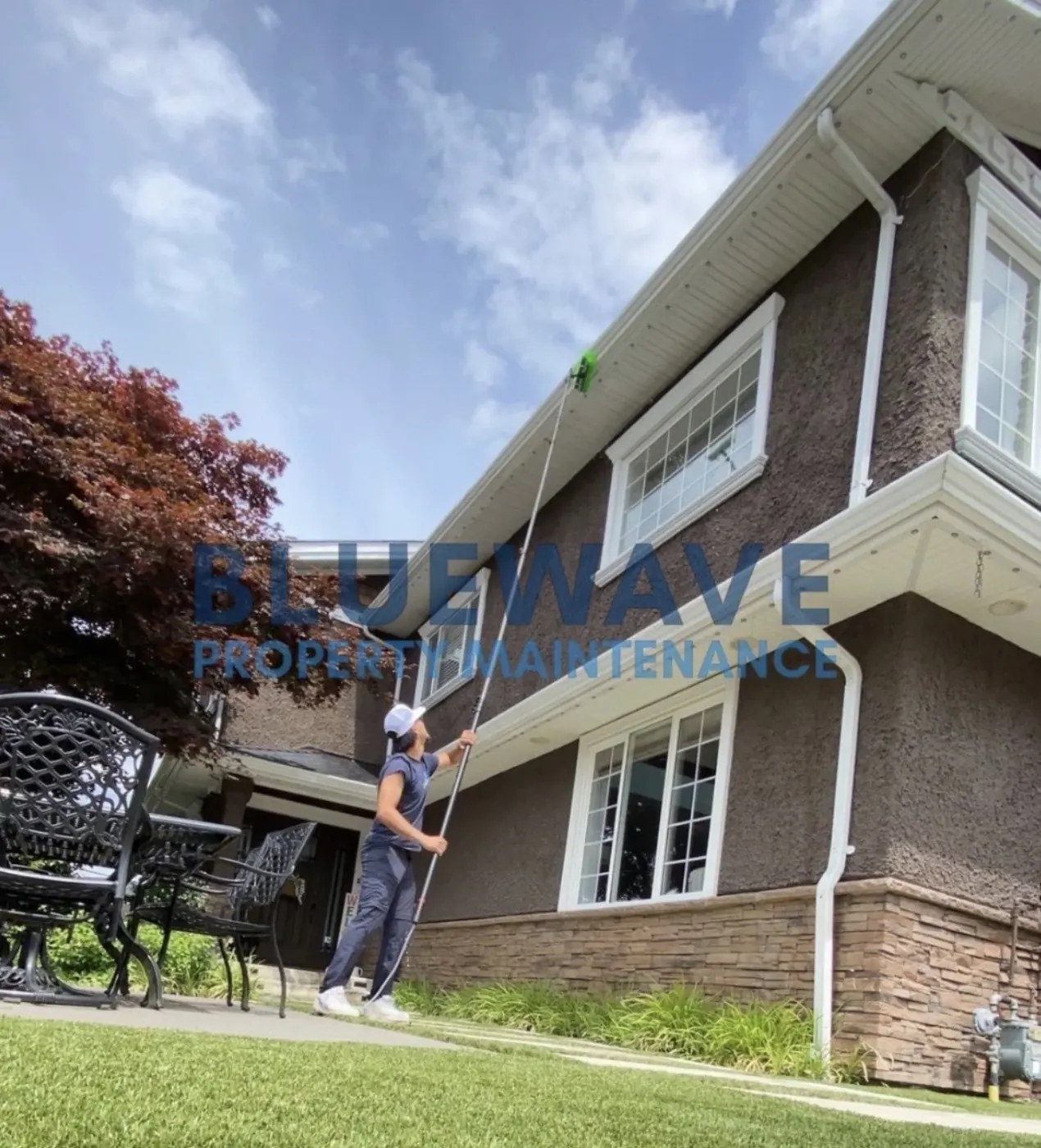 BlueWave technician clearing a gutter with a reach pole